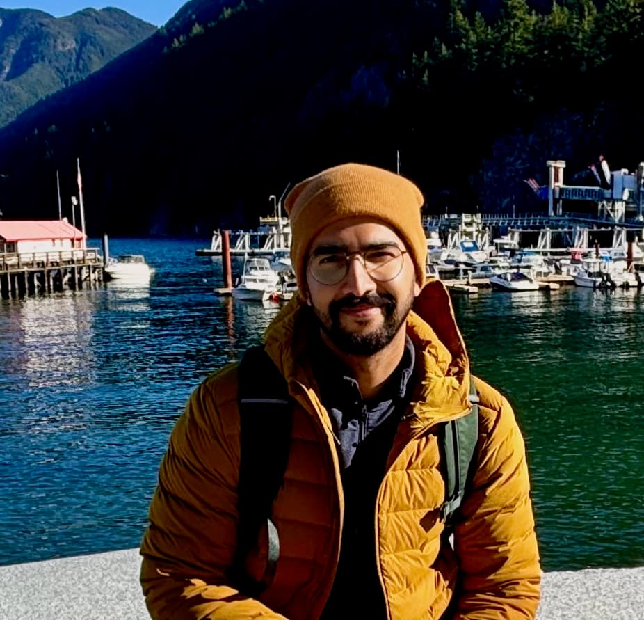 Amit, the founder of Canada Grants Database, standing in front of a harbour in Vancouver